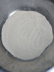 close-up view of a mound of white flour in a gray bowl