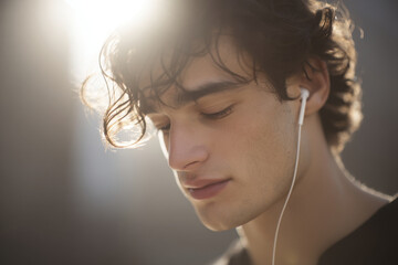 closeup of indie musicians face immersed in sunny morning music in their ears
