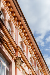 A charming European street lined with pastel-colored historic buildings, ornate architectural details, and a nostalgic atmosphere under a soft daylight sky