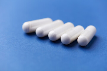 Arginine capsules on bright background. Soft focus. Close up. Copy space.	