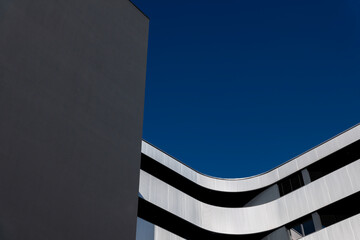 Beautiful Modern Concrete Design Building with Metal Balcony Against Blue Clear Sky in Switzerland.