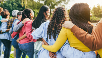 Multi generational women hugging each others - Female multiracial group having fun together outdoor - Friendship and people support concept - Main focus on right girl head