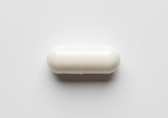 Close-up of a single white capsule pill on a plain white surface, showing the shape and texture of the medication