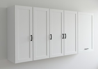 Naklejka premium White cabinets with black handles hang on a white wall, one cabinet door is slightly ajar