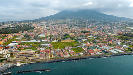 Fototapeta premium Aerial view of the modern city of Herculaneum, in the province of Naples, Italy. The city is a resort and the starting point for excursions to Vesuvius volcano. In foreground is the Mediterranean sea 