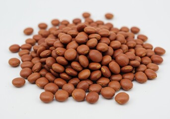 Heap of mucuna seeds against a white background, close-up