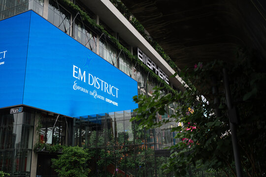 BANGKOK, THAILAND - JUN 26, 2024: Exterior view of EMSPHERE at EM District in Bangkok, featuring a large digital screen and lush green vertical garden facade on the modern glass building.