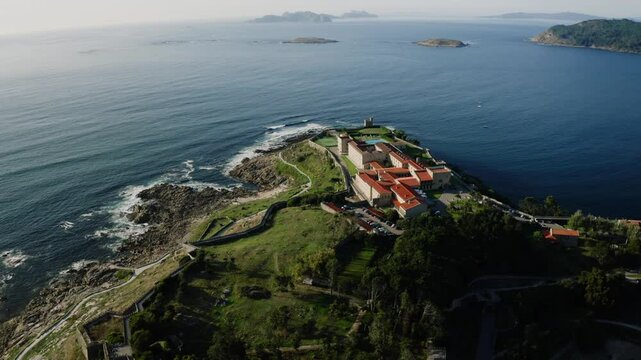 Hotel Parador On Top Of Green Coastal Hill Surrounded By Ocean In Baiona Spain, Aerial View