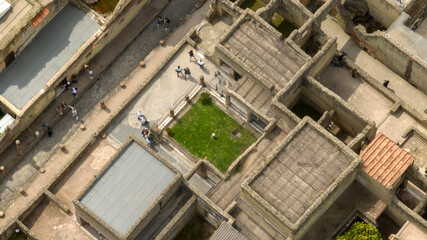 Fototapeta premium Aerial view of the street, ruins and excavations of Herculaneum. It is an archaeological area of ​​an ancient Roman city, near Pompeii, in the province of Naples, Italy. It is a tourist destination.