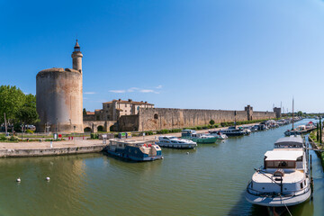 Aigues-Mortes, Camargue, France. The outer fortified wall of the medieval city, with a canal and boats in the foreground