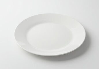 Simple presentation of a plain white dinner plate on a white surface in a studio setting