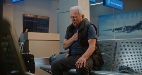 Crowded International Airport Terminal: Senior Man Having Heart Attack, Clutching Chest in Pain...