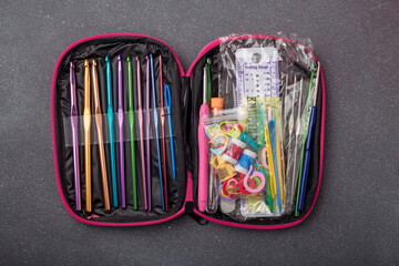 Crochet tools kit, set of crocheting hooks in a case. Organizer with thimble, pins, markers and other equipment for creative handicraft