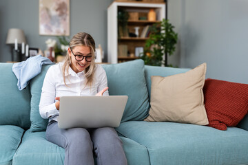 Young freelance business woman having video call conference on laptop computer while sitting and...