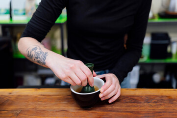 Barista preparing coffee using bamboo whisk called chasen