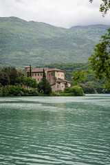 Scenic View Of Lake Toblino, Italy, Framed By Trees With A Historic Castle On The Shore