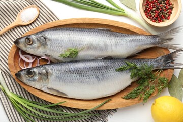 Salted herrings and spices on white wooden table, flat lay