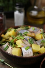 Delicious salad with herring on wooden table, closeup