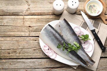 Tasty herring fillets with spices on wooden table, flat lay. Space for text