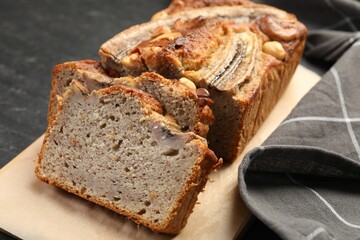 Cut banana bread with nuts on black table, closeup