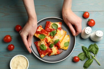 Woman with delicious ravioli at blue wooden table, top view