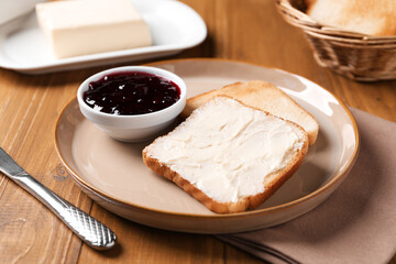 Slices of tasty toasted bread with butter and jam on wooden table, closeup