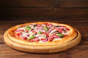 Tasty pizza with smoked sausages and mushrooms on wooden table, closeup