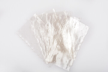 Obraz premium Several translucent sheets of leaf gelatin are slightly overlapping on a light gray background