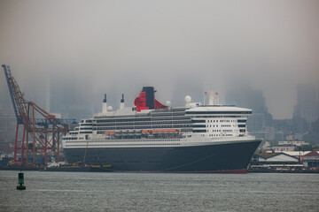 Luxury ocean liner cruiseship cruise ship Queen Mary docked at terminal in Brooklyn on grey rainy...