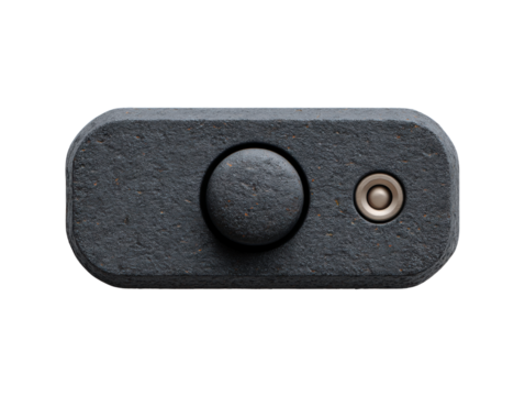 A dark gray textured electronic device shows a circular button and metal port against a clean white background in a close up studio shot showcasing its design.