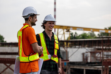 Two Caucasian civil engineers have handshake to celebrate a successful deal in a precast factory. Expression of cooperation between two civil engineers through handshake in a construction factory