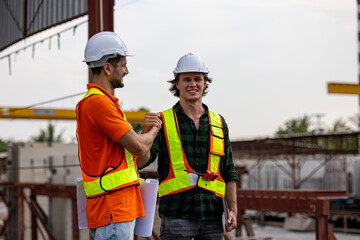 Two Caucasian civil engineers have handshake to celebrate a successful deal in a precast factory. Expression of cooperation between two civil engineers through handshake in a construction factory