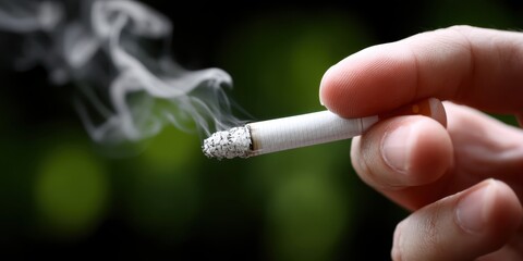 Close-up photo of a hand extinguishing a cigarette, with smoke in the background