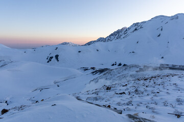 2025年4月30日、富山県立山町のみくりが池近くのエンマ台から撮影した、日の出前の雪山風景。地平線上にはビーナスベルトが淡いピンクと青のグラデーションを描き、静寂に包まれた立山連峰の風景を幻想的に彩っています。