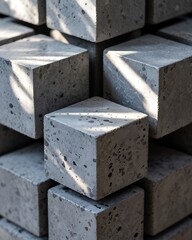 Grey Concrete Cubes Stack: Abstract arrangement of grey speckled concrete cubes, illuminated by sunlight, creating a visually interesting pattern and texture.