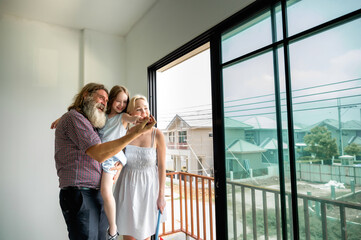 Happy family inspects their new home together, looking out the front door, the porch, and imagining...