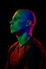 Side view portrait of handsome bald man in black t-shirt posing with confident and serious...