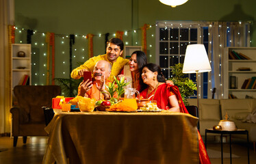 Indian family connects with relatives on a video call during festive Diwali celebration at home