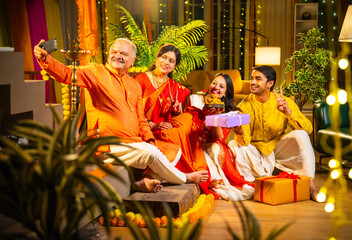 Indian family capturing Diwali memories indoors, surrounded by festive decor, smiles, and sweets