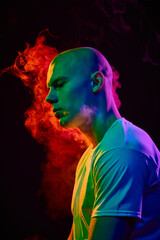 Side view portrait of handsome bald man in his 20s, looking to left with thoughtful expression on...