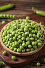 fresh green peas on wooden table.