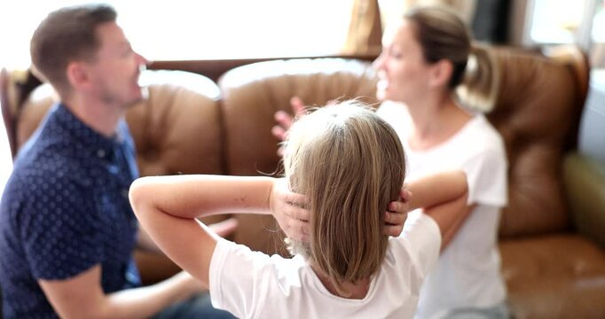 Little girl covers ears while parents argue on sofa highlighting family conflicts and impact on child. Emotions of stress and anxiety fill room