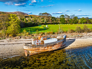 View of Corpach Wreck or Old Boat of Caol and Nevis Range Mountains from a drone, Caol Beach,...