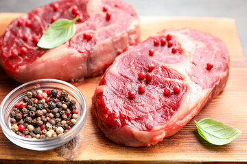 Pieces of raw beef meat and spices on table, closeup