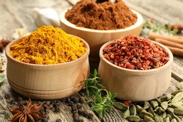 Different aromatic spices on wooden table, closeup