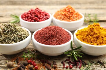 Different aromatic spices on wooden table, closeup