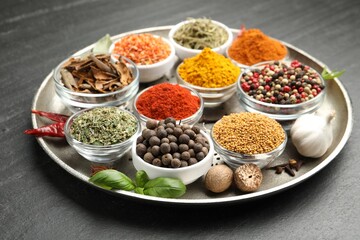 Different aromatic spices on black table, closeup