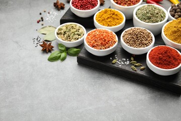 Different aromatic spices on grey table, closeup. Space for text