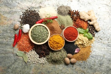 Many different spices on grey table, flat lay
