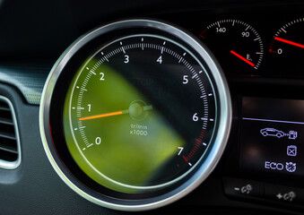 Fototapeta premium Close-up of car tachometer showing engine idle speed and eco mode